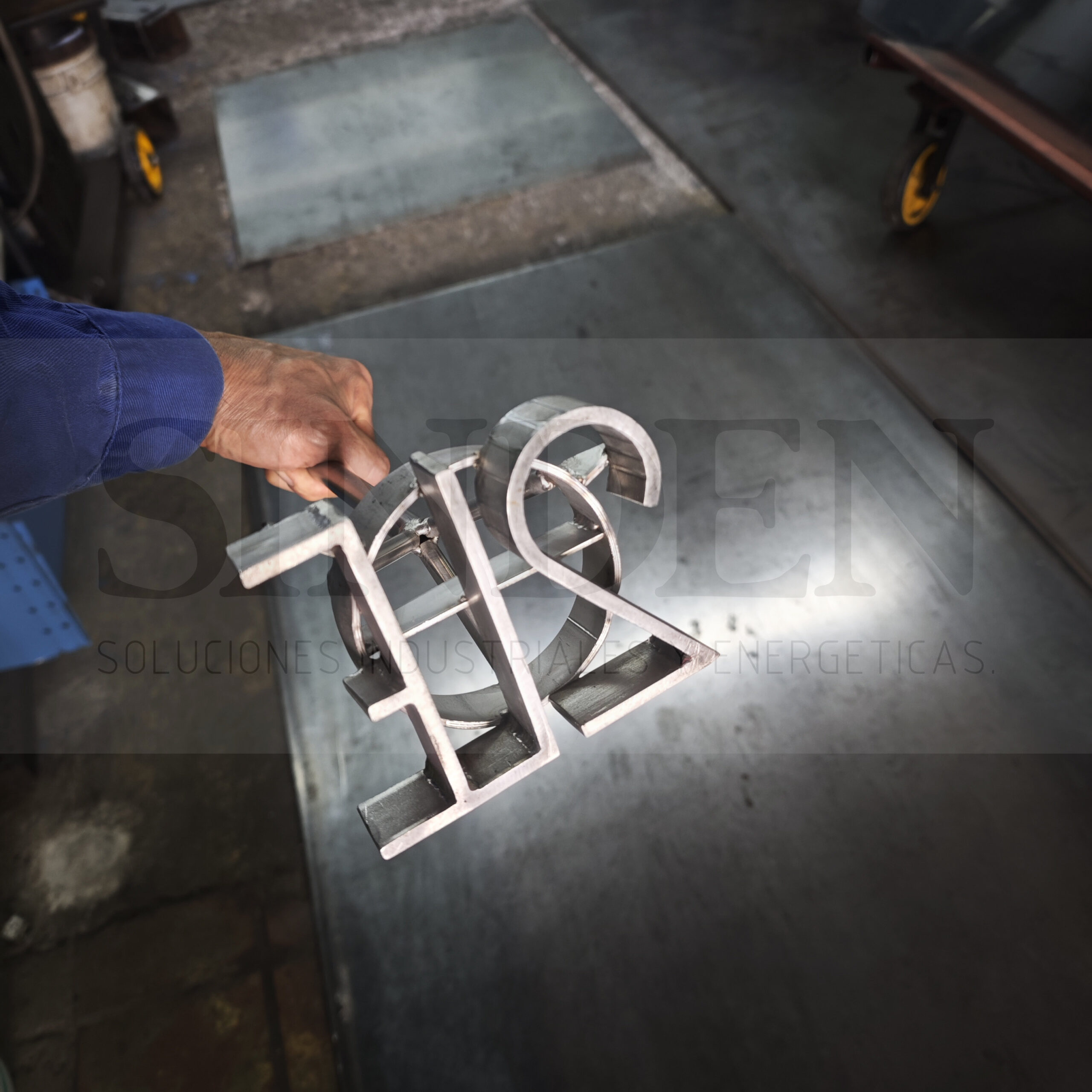 Marca de ganado con letras y números, sostenida en la mano