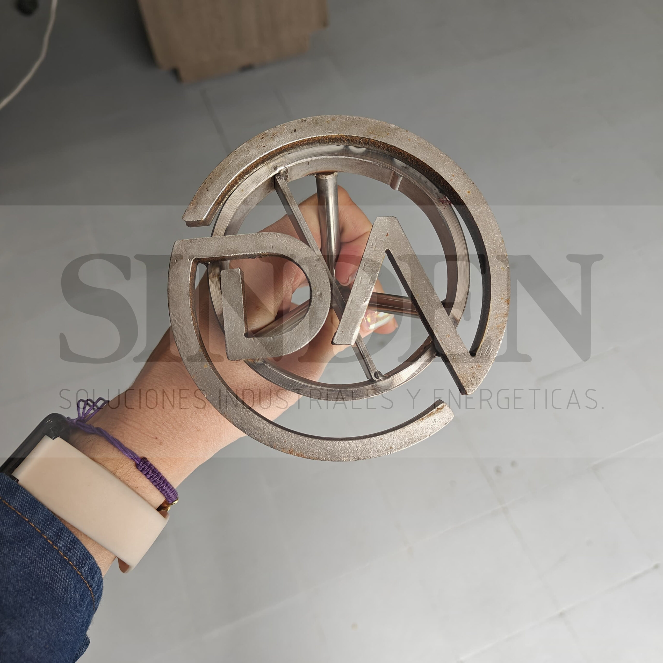 Marca circular con letras, sostenida en la mano