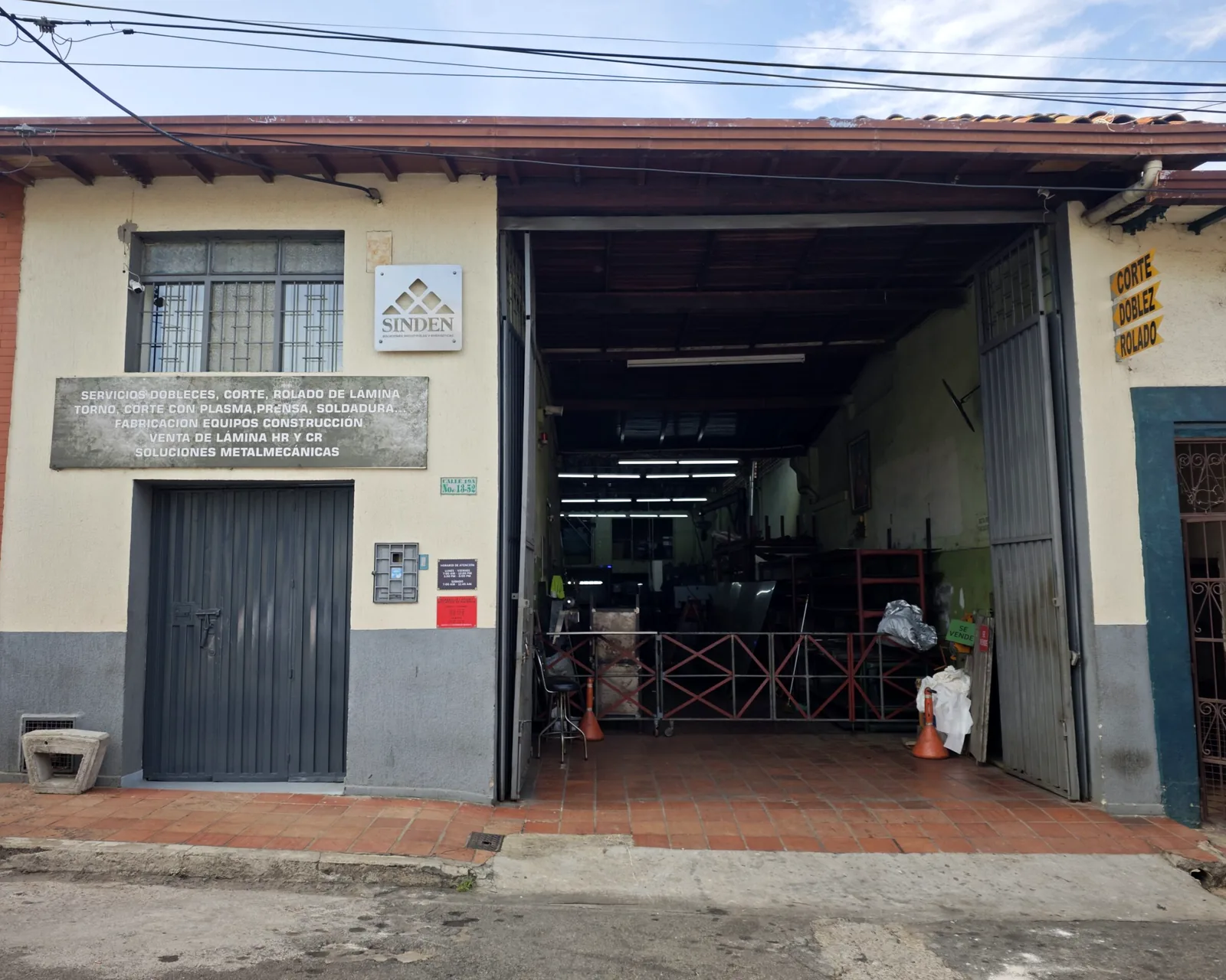 Fachada del taller de SINDEN S.A.S. en Bucaramanga, con el portón abierto