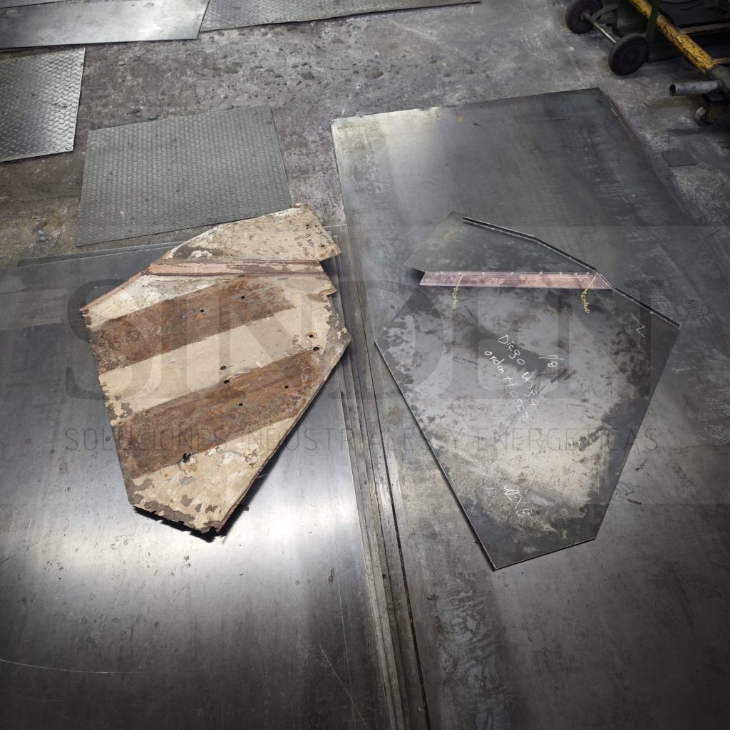 Pieza original oxidada y la lámina nueva marcada a partir de ella para reconstruirla